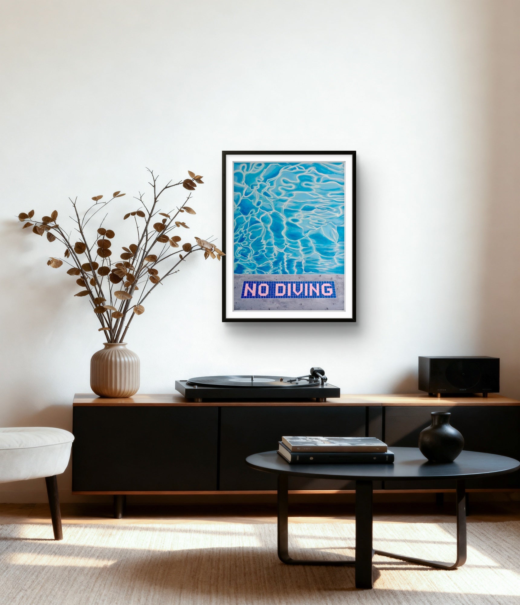 Framed 'No Diving' poster on a wall above a turntable in a living room.