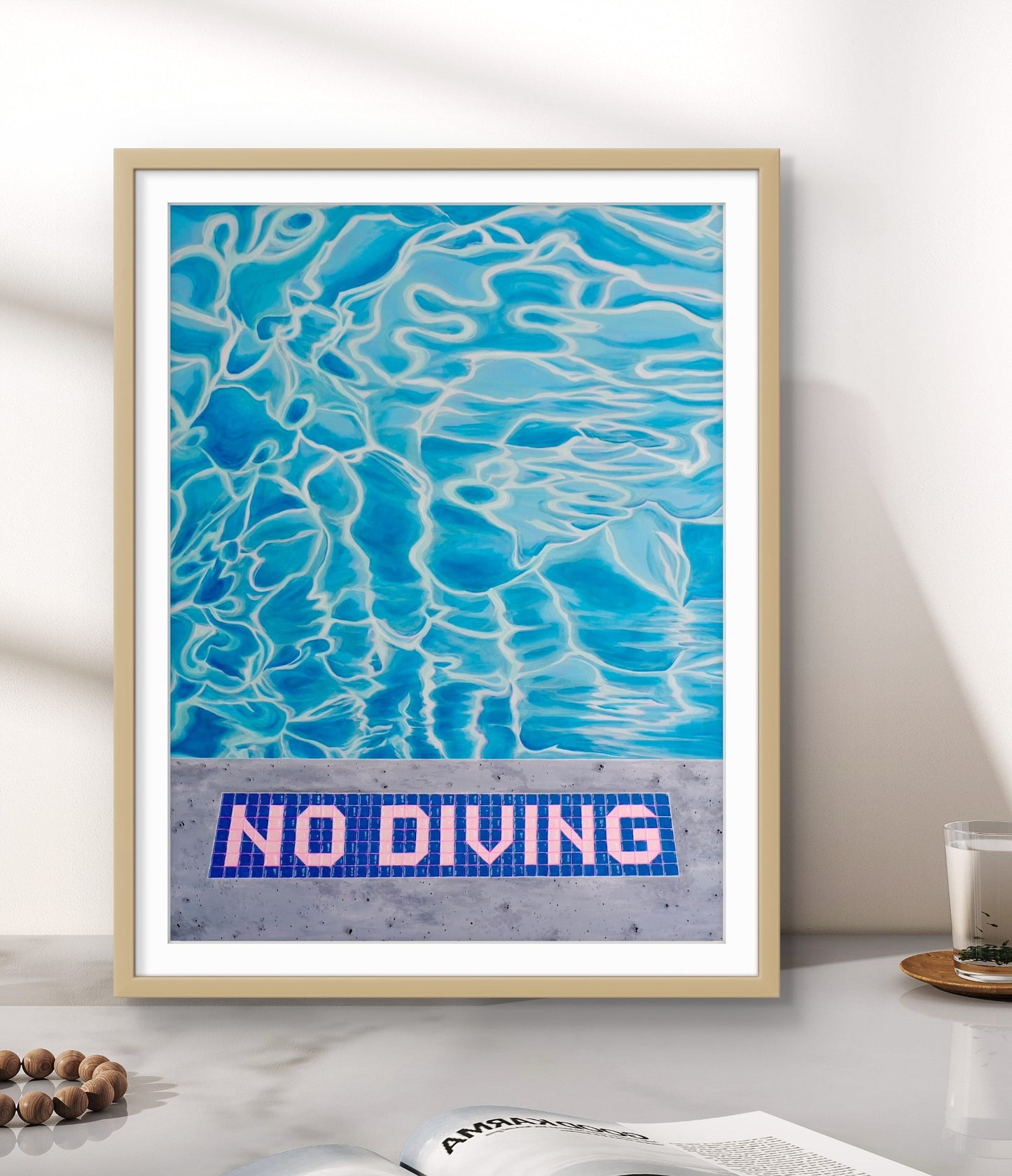Framed artwork of a pool with 'No Diving' sign on a white wall.