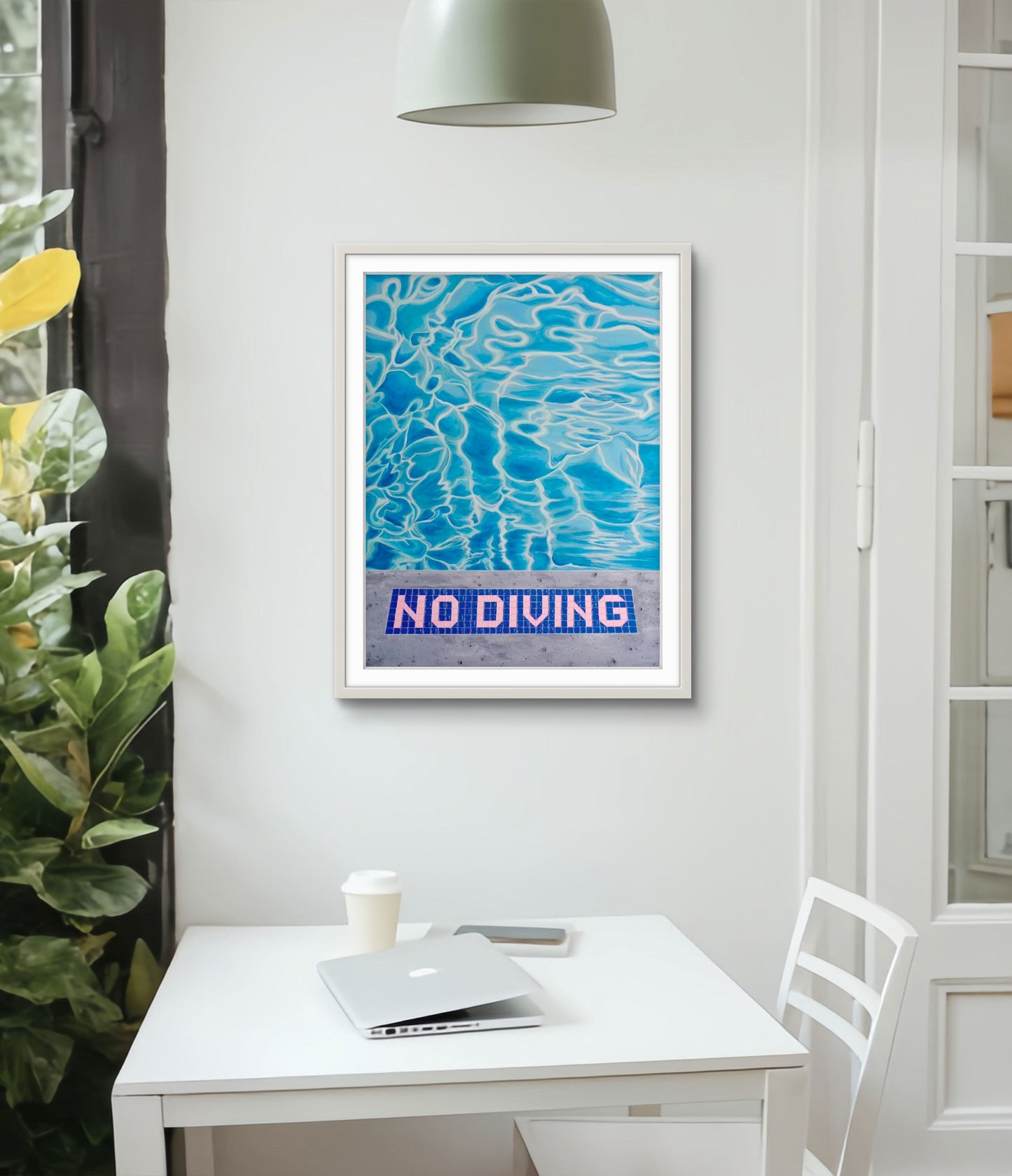 Framed artwork with 'No Diving' text on a wall above a desk.