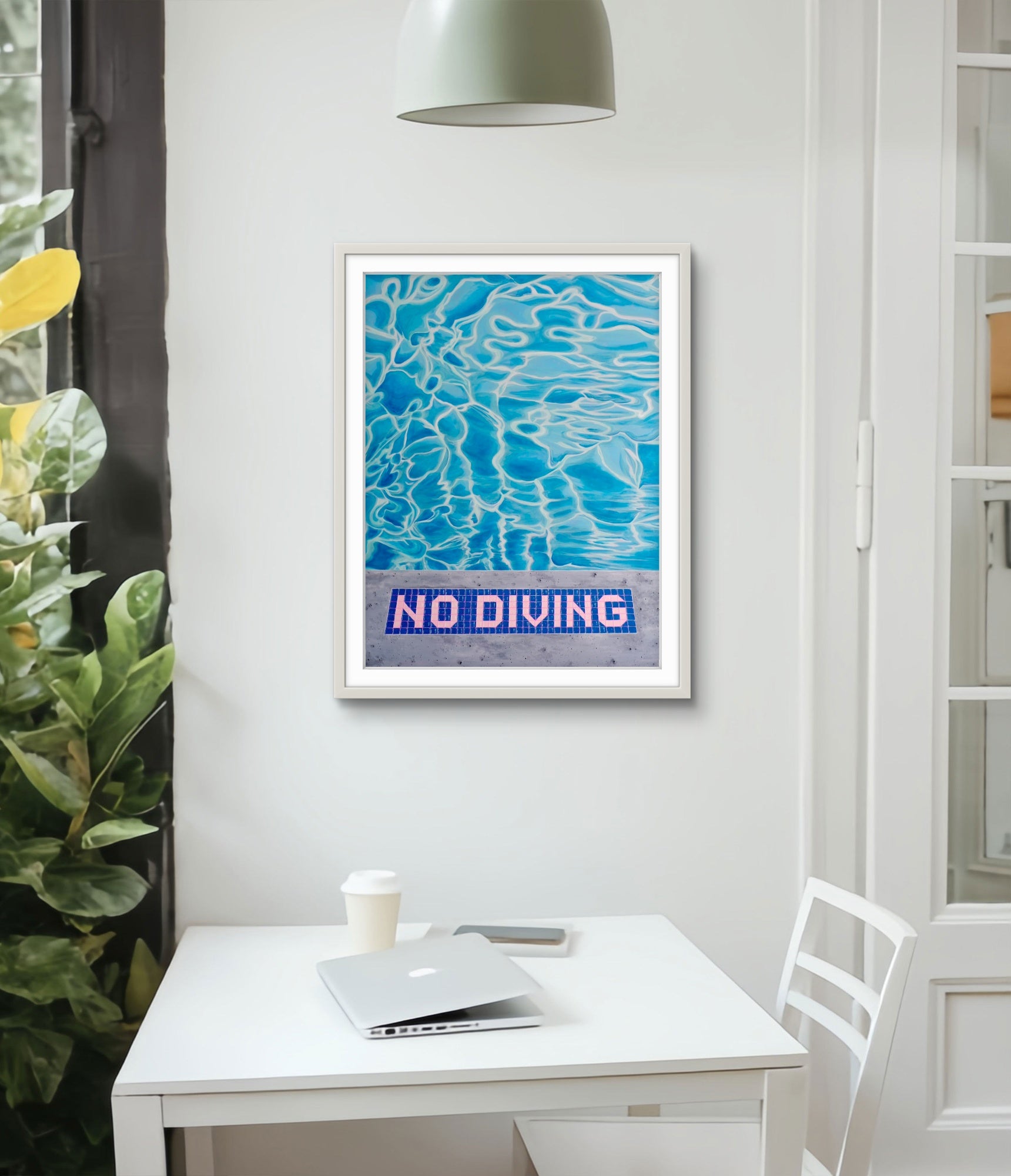 Framed artwork with 'No Diving' text on a wall above a desk.