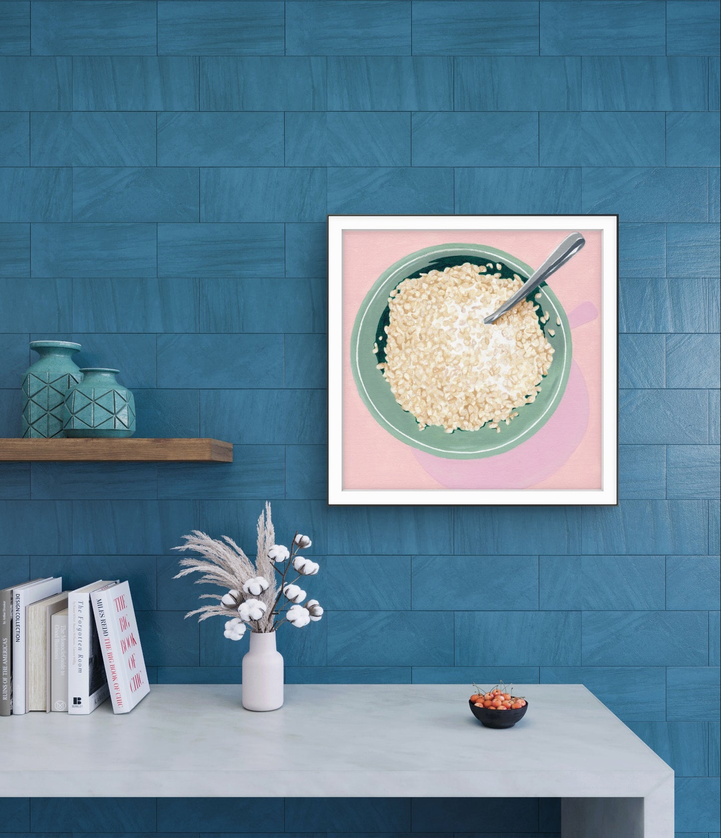 Framed artwork of a bowl of cereal on a blue wall with a shelf and books below.