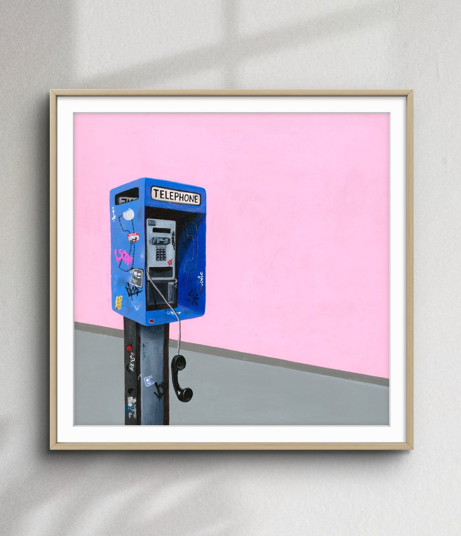 Framed artwork of a blue telephone booth against a pink background