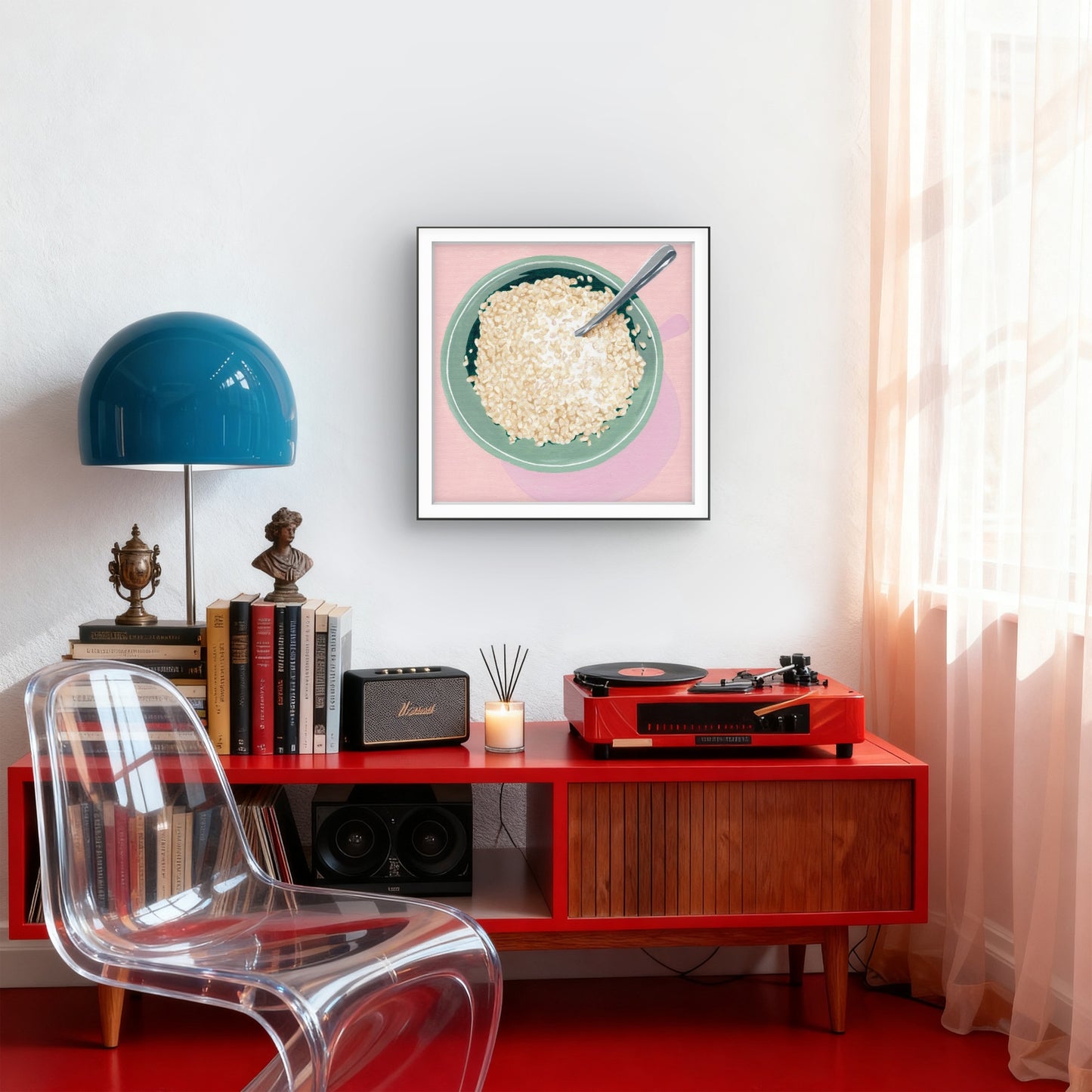 Modern interior with red console table, clear chair, blue lamp, and framed artwork.