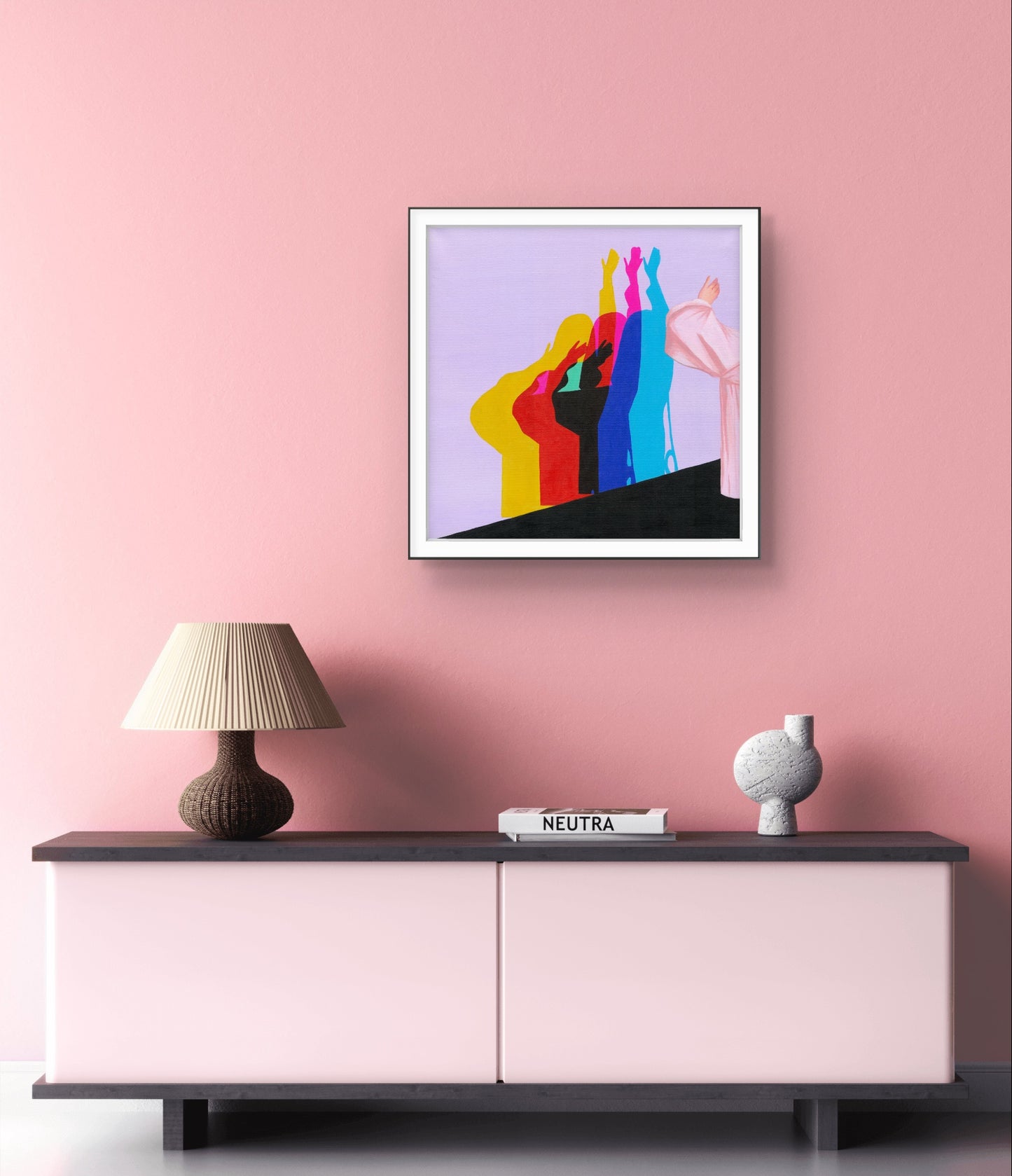 Colorful abstract art on a pink wall above a pink and black cabinet.
